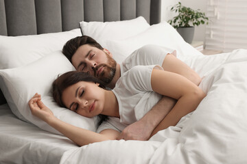 Lovely couple sleeping together in bed at home