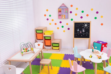 Stylish kindergarten interior with toys and modern furniture