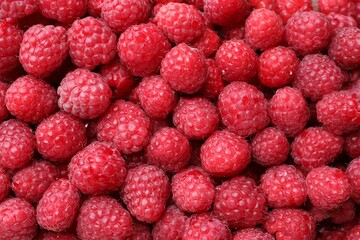 Heap of tasty ripe raspberries as background, top view