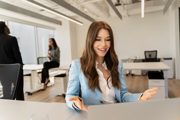 Beautiful woman having video conference, explaining, looking at screen. Successful businesswoman