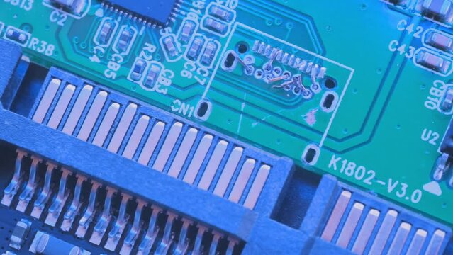 Microchips top view in blue light, CPU processor. Computer motherboard components. PC chip close up, slowly tracking shot.