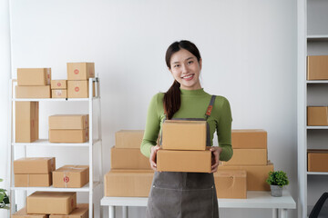 Young beautiful small business shop owner checking order, preparing for distribution to customers.