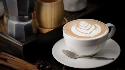 A cup of cappuccino coffee with soft foam on a wooden table. The coffee moment concept is everywhere.