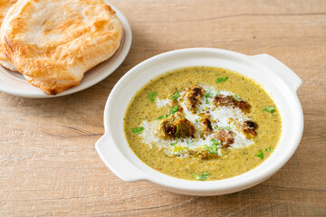 Afghani chicken in green masala curry or Hariyali tikka chicken hara masala with roti or naan bread