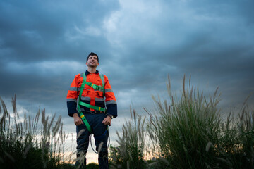 Portrait of a young man working in wind turbine field, wearing a safety vest, The concept of relax time after work