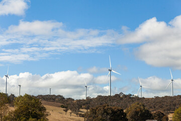 Wind turbines on horizon along ridgeline above road in rural NSW