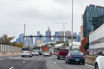 Traffic on multi lane city road to Melbourne CBD with variable speed limit signs reading 80