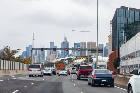 Traffic on multi lane city road to Melbourne CBD with variable speed limit signs reading 80