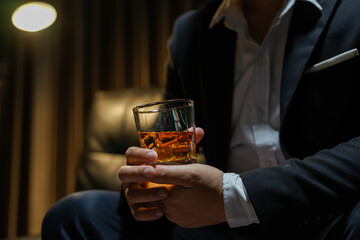 Closeup businessmen holding a glass of whiskey