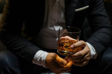Closeup businessmen holding a glass of whiskey
