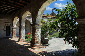 Fototapeta na wymiar Stone arches and gardens at Mission San Juan Capistrano
