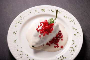Chile en Nogada, Typical dish from Mexico. Prepared with poblano chili stuffed with meat and fruits and covered with a walnut sauce. Named as the quintessential Mexican dish for national holidays.