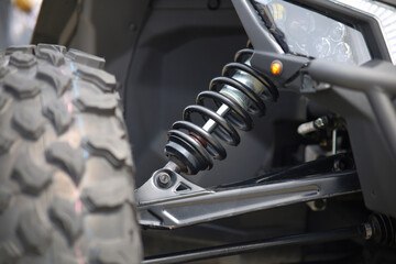 Close-up of new suspension system and shock absorber of car with wheel. Automotive part of atv off...