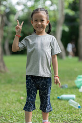 Smiling little girl standing with two thumbs up fighting gesture in nature, concept of future ecology and resources, saving the planet. Bright future.