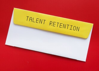 Office envelope on red background with text typed TALENT RETENTION - set of practices and policies...