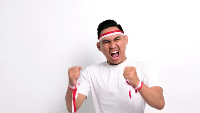 Excited young Asian men celebrate Indonesian independence day on 17 August by raising fists isolated over white background