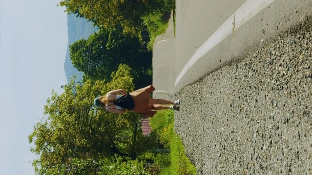 Vertical tourist walks along a hot highway under the scorching rays of the sun