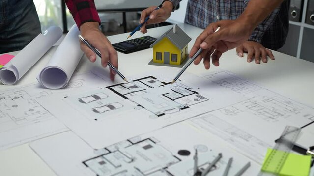 Construction concept of meeting engineers or architects for projects working with partners and engineering tools on modeling and blueprint design in office.	