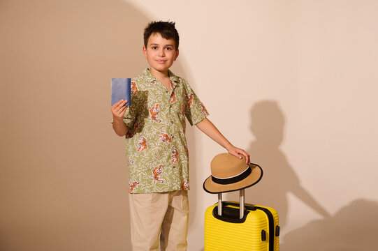 Charming Hispanic traveler teen boy with yellow suitcase, going for weekend getaway, travelling abroad. Summer holidays - Powered by Adobe