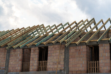 Fototapeta premium Residential construction site of terraced house or row homes. Roof truss wooden framework, structural components that provide support to the roof.
