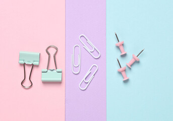 Paper clip holders and pins on a pastel background. Minimalism. Creative layout