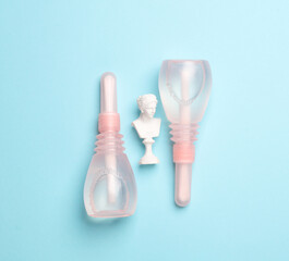 Vaginal enemas with Venus bust on a blue background. Women's health