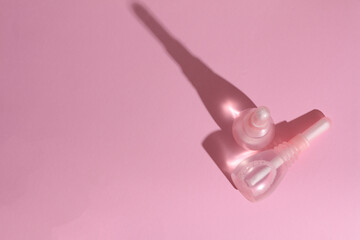 Vaginal enemas on pink background. Women's health. Top view with shadow