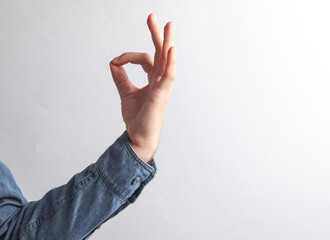 Man's hand in a denim shirt shows a zen symbol on a gray background. Overcome stress. business concept