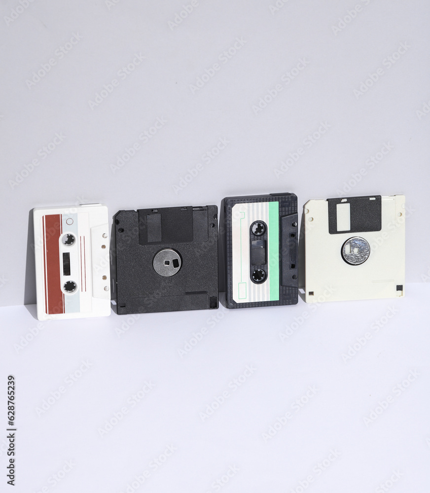 Poster retro 80s audio cassettes and floppy disks on white background with shadow. creative layout, minimal