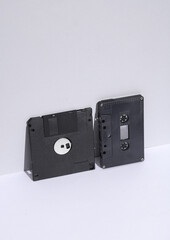 Obraz premium Retro 80s floppy disk and audio cassette on white background with shadow. Creative layout, minimalism