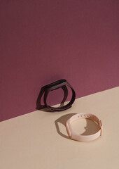 Smart bracelet with interchangeable silicone bracelets on a colored background with a shadow. Creative layout