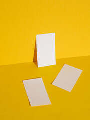 White business cards on yellow background with shadow. Creative layout