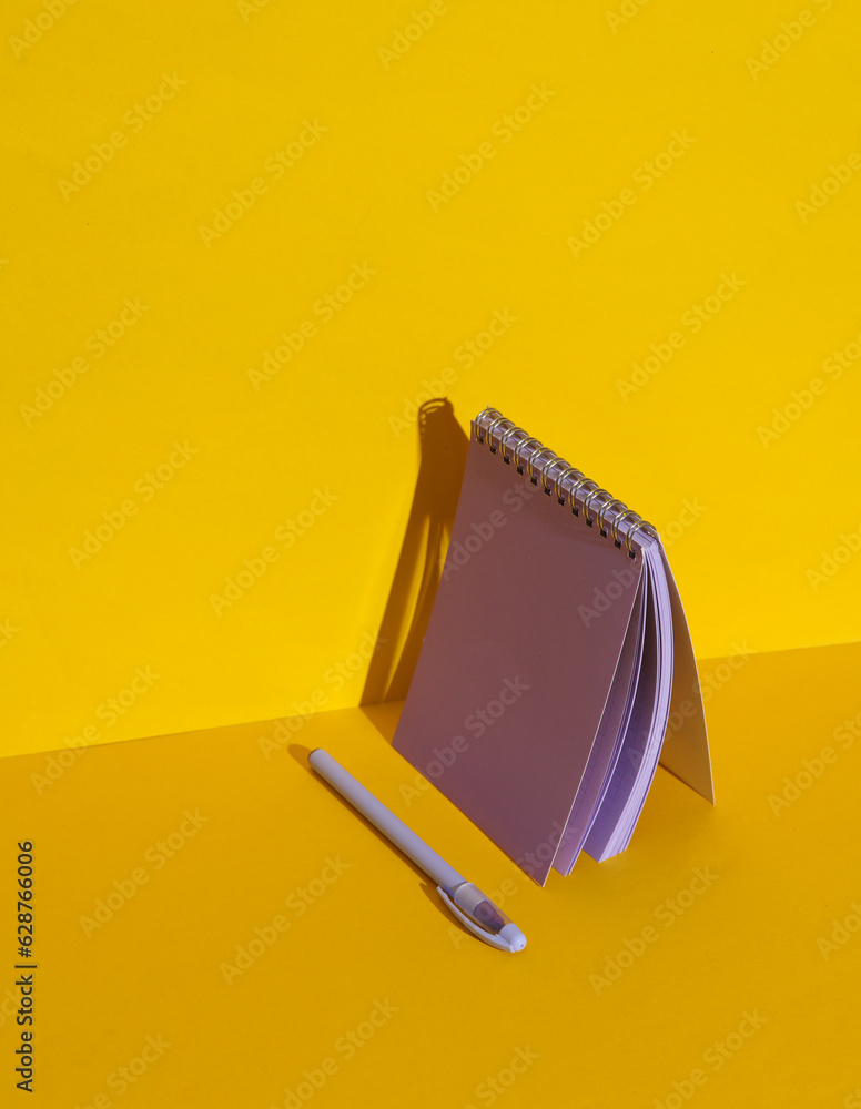 Poster purple notebook with pen on yellow background with shadow. creative layout