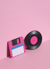 Vinyl record and floppy disk on pink background with shadow. Minimalism. Retro 80s creative layout