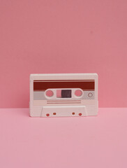 Fototapeta premium Outdated technologies. Retro 80s audio cassette on pink background. Creative layout