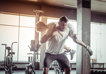 Healthy family concept. Father squats with his son on his shoulders in the gym. Fitness, sports,...