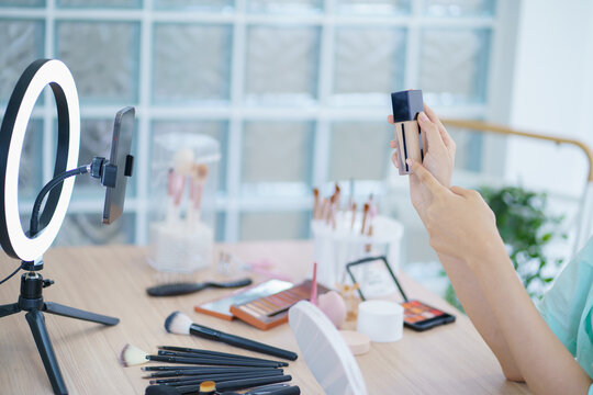 Young Asian girl makeup artist Professional Woman blogger vlogger is showing cosmetics products with recording video beautiful asian girl video online marketing.