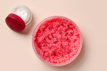 Jars with body scrub and cream on color background