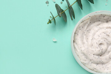 Fototapeta premium Jar of body scrub and eucalyptus branch on color background