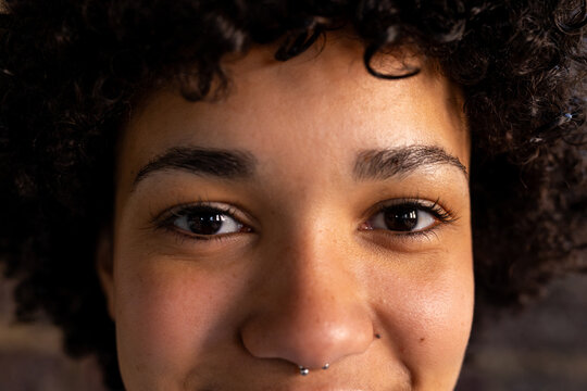 Portrait of happy biracial casual businesswoman with nose piercing smiling at office