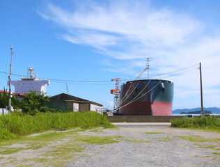 Fototapeta na wymiar 造船所脇の堤防に停泊中のタンカー。 瀬戸内海工業地帯の風景。