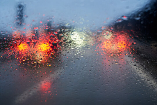 Raindrops on the car window. Bad weather and low visibility on the highway.