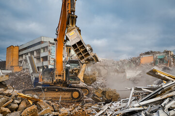 Excavator with hydraulic press breaks concrete leftovers