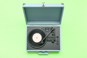 Fototapeta premium Record player with vinyl disk on green background