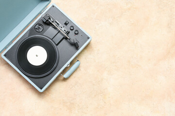 Fototapeta premium Record player with vinyl disk on beige background
