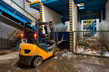 The bulldozer loader compacts the sorted waste in the storage bin. Separate sorting of household waste