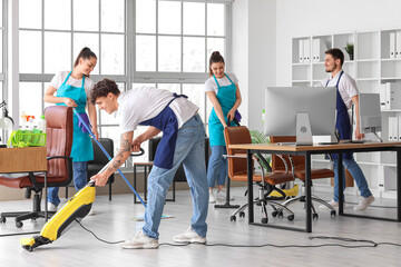 Young janitors cleaning in office