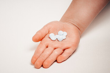 Different types of pills in the palm of a young child