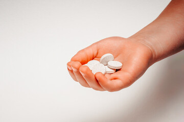 Different types of pills in the palm of a young child