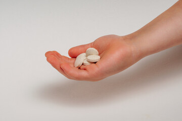 Different types of pills in the palm of a young child